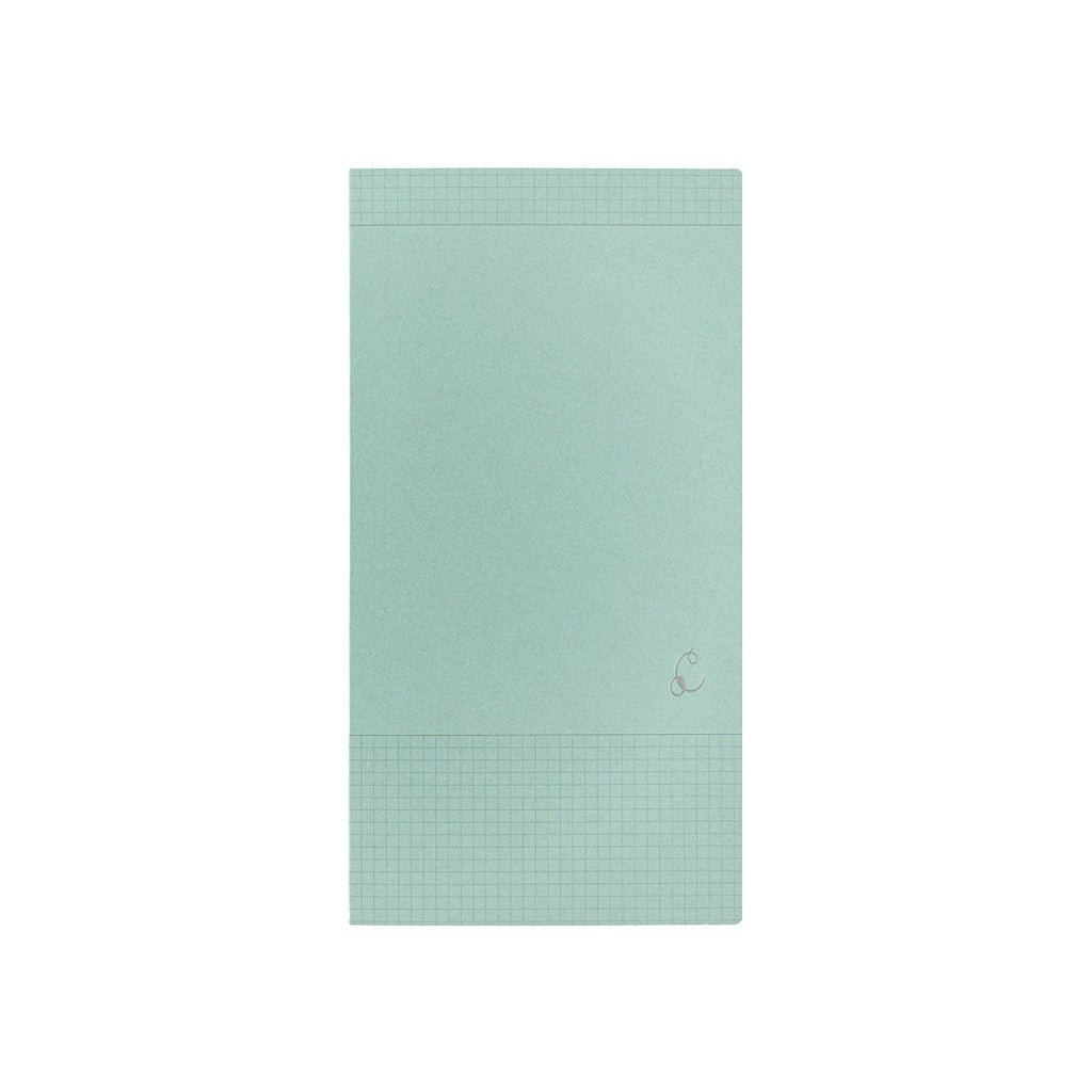 A mint green notebook with grid lines on the top and bottom borders, featuring a small silver monogram logo on the lower right, set against a plain white background.