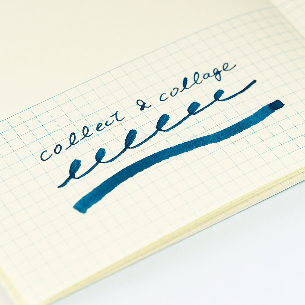 A close-up of a hand-written note on graph paper, showing the cursive text 'collect & collage' written in dark blue ink with a matching underline.