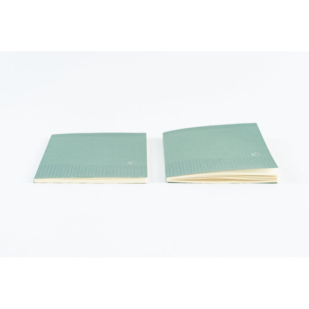 Two mint green lined notebooks with cream-colored pages, displayed side-by-side on a clean white background.