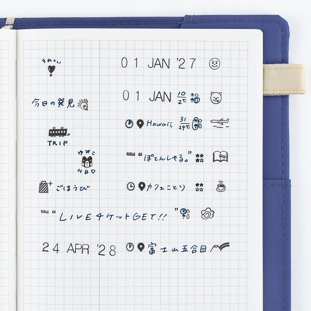 A blue notebook cover with a white grid page insert, showing handwritten Japanese notes and small stamped icons in blue ink.