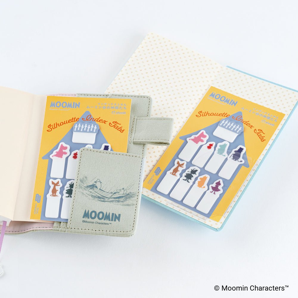Moomin Silhouette Index Tab sets shown in two open notebooks. The set includes colorful character-shaped index tabs with a yellow and blue design, and a small matching tab cover featuring the Moomin logo.