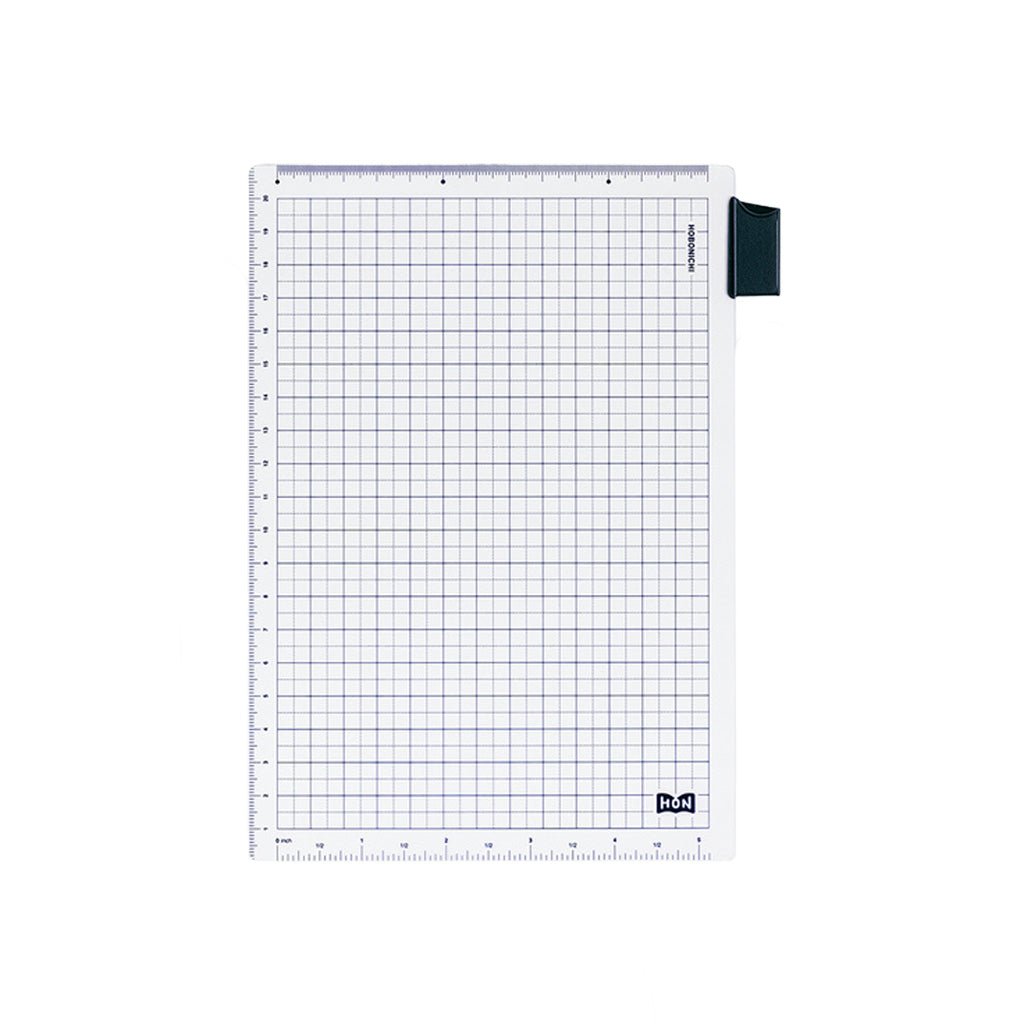 A clear A5-sized pencil board for Hobonichi Techo HON with dark blue grid pattern, ruler measurements, and bookmark tab against white background