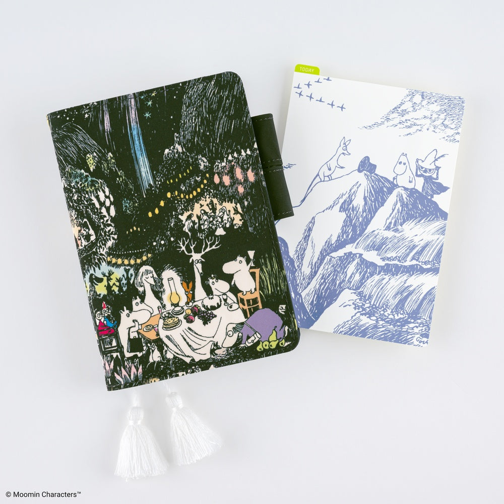 An A6-sized notebook cover with a Moomin dinner party design next to a pencil board with a light blue Moomin illustration against a white background