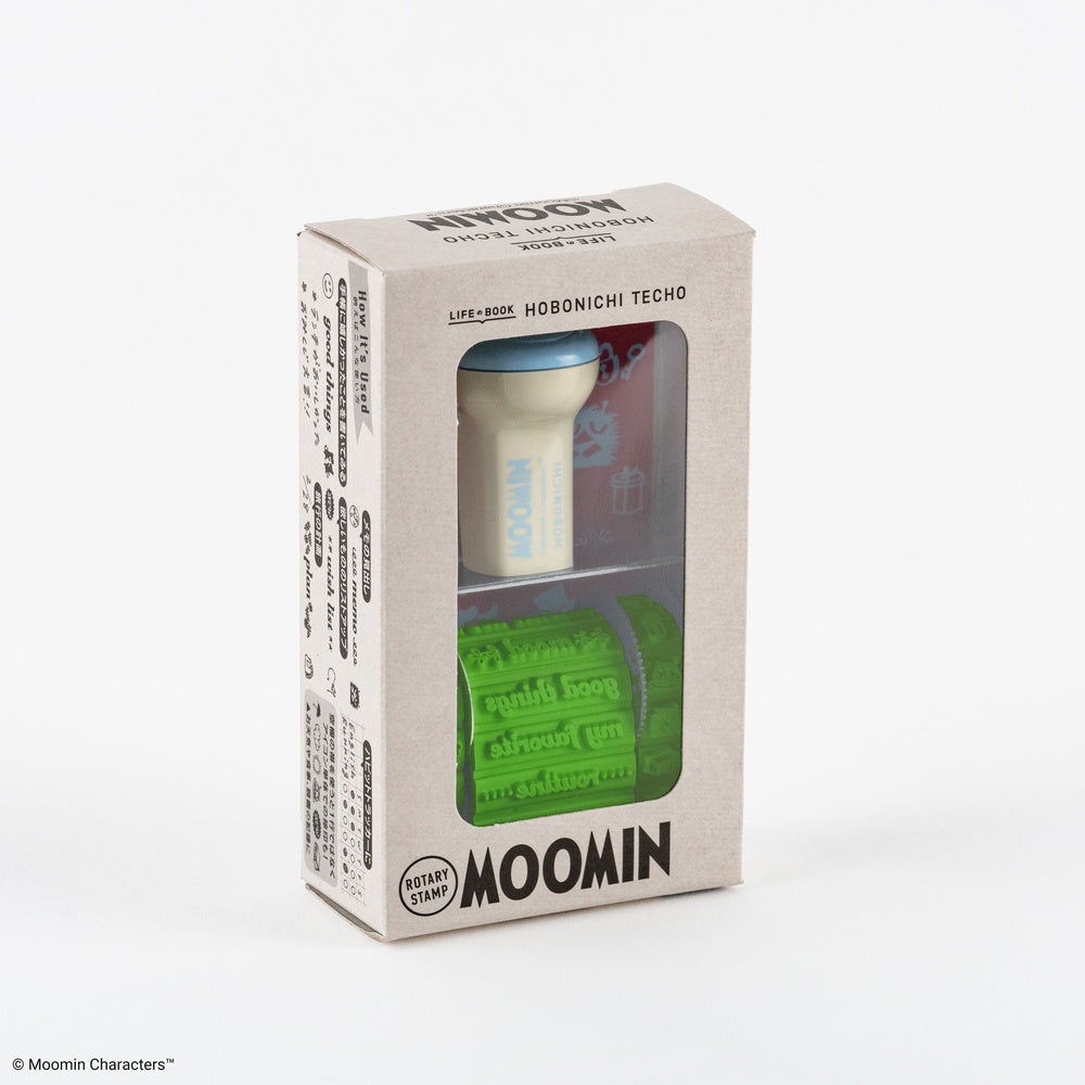 Moomin character rubber stamp in its packaging, featuring a white holder with a blue cap and a green textured stamp, visible through a clear plastic window on a light gray box.