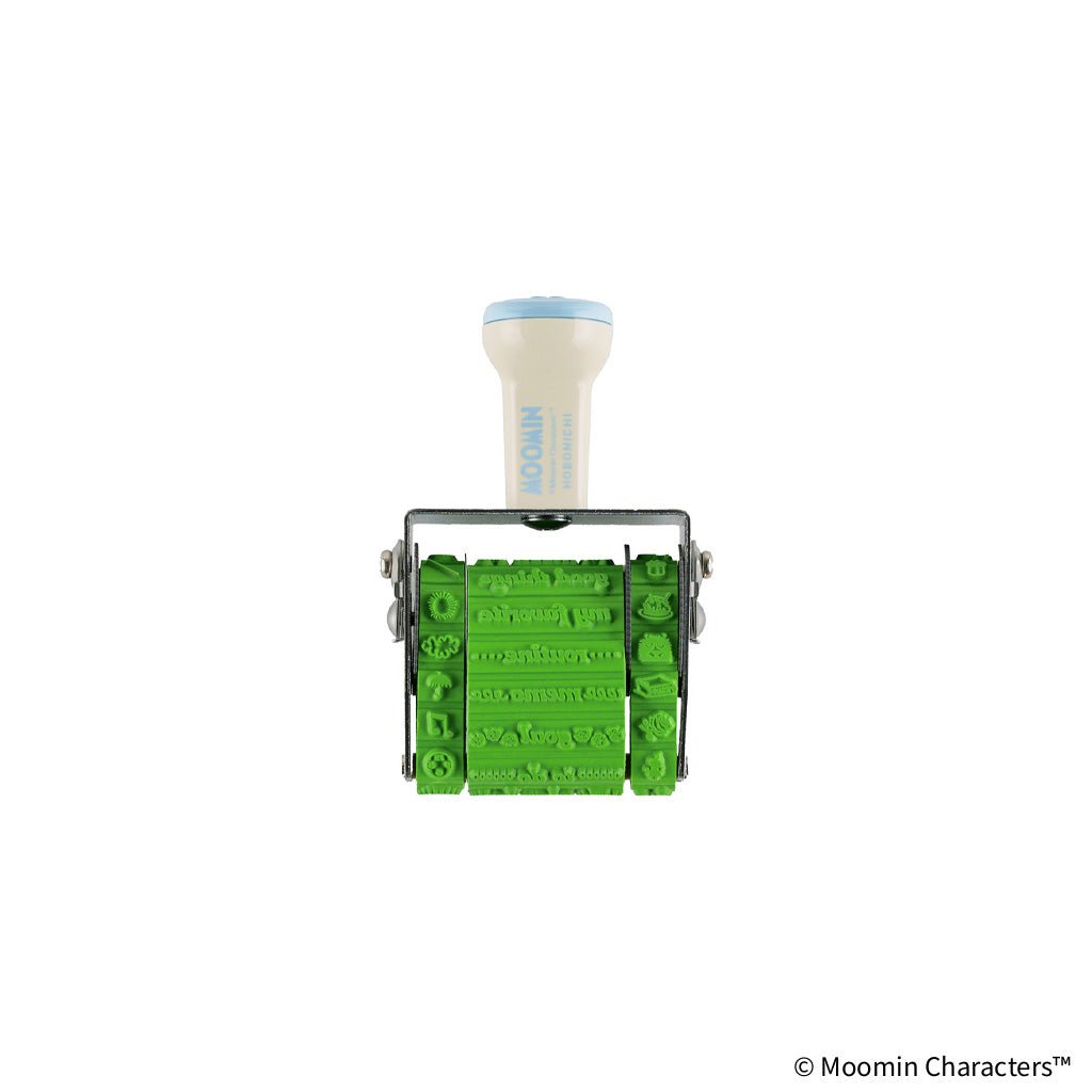 A Moomin-themed rubber stamp roller with a cream-colored handle, light blue trim, and bright green embossed lettering, shown on a plain white background.