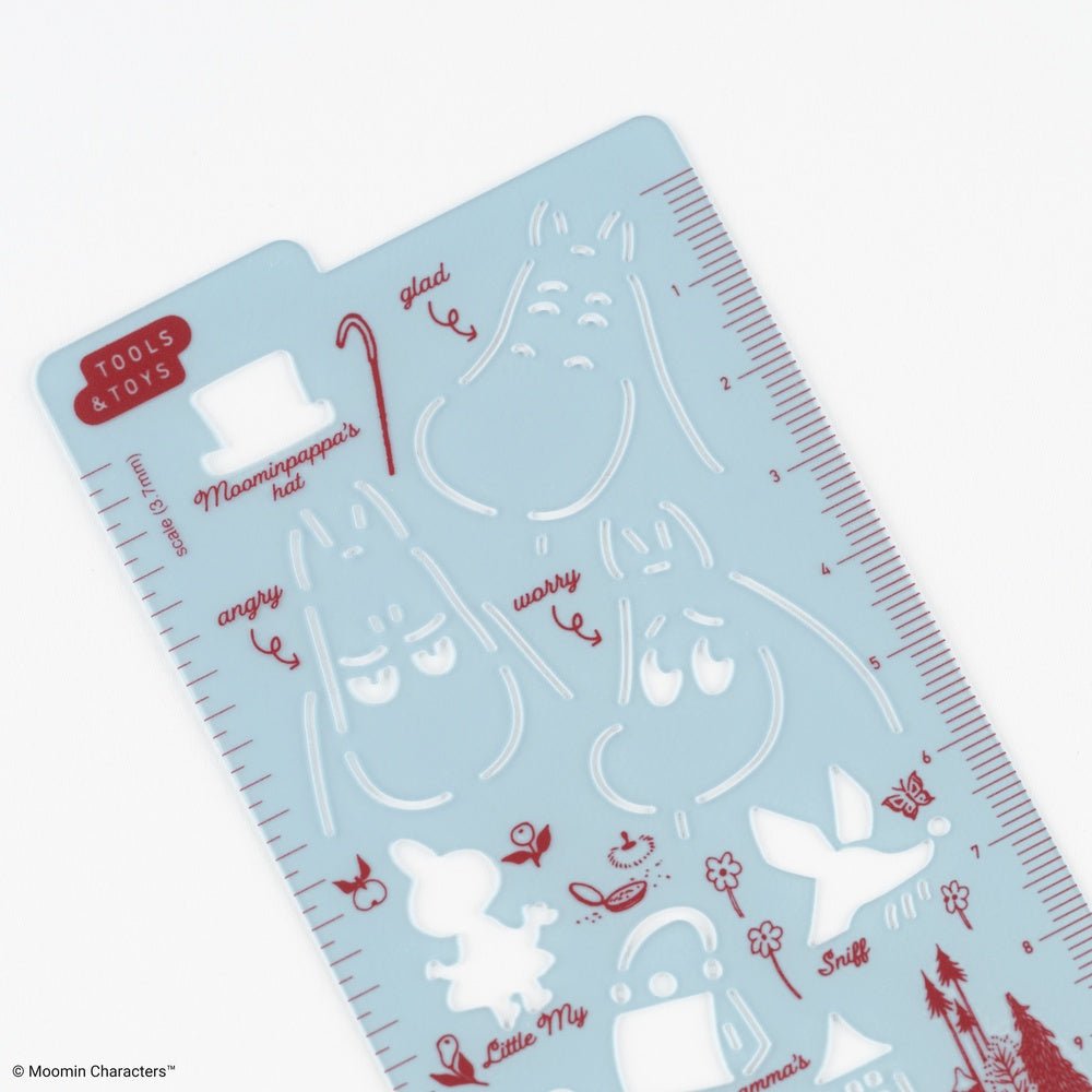 A light blue plastic craft stencil sheet featuring red and white line-art illustrations of Moomin characters and facial expressions, with measurement markings along the right edge.
