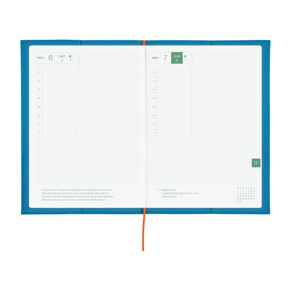 An open daily planner with a bright blue cover, white grid pages, and a red ribbon bookmark, photographed on a plain white background.