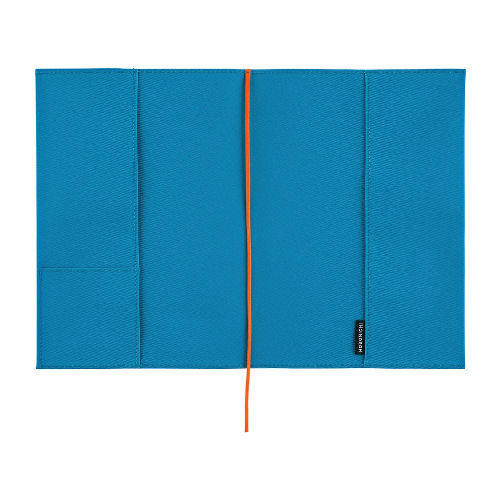 The interior of a bright blue Hobonichi Techo cover with pockets and a bright red ribbon bookmark, shown flat against a white background.