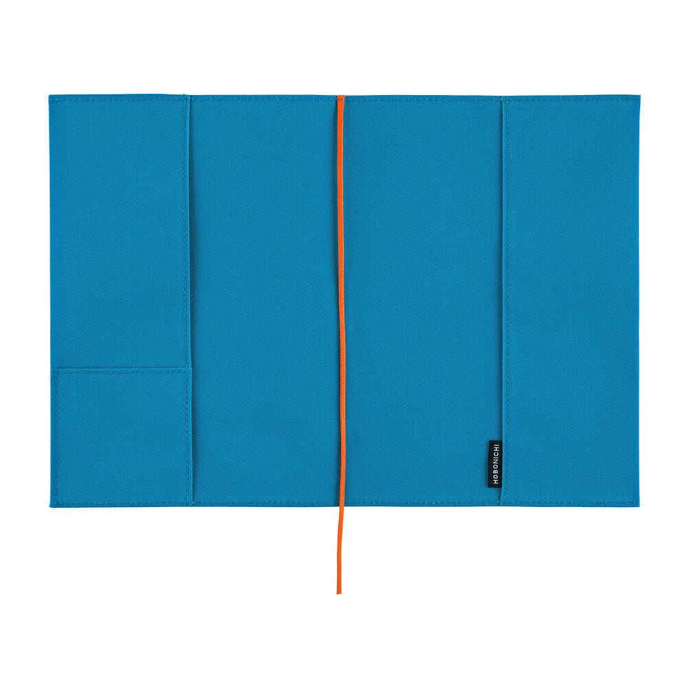 The interior of a bright blue Hobonichi Techo cover with pockets and a bright red ribbon bookmark, shown flat against a white background.