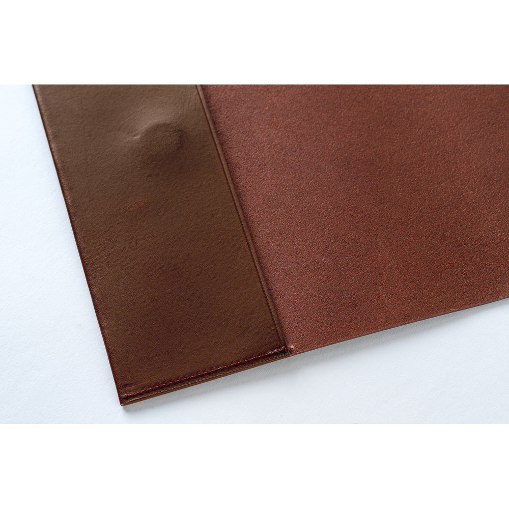 A close-up of a brown leather, showing a smooth textured panel and a stitched edge on a plain white background.