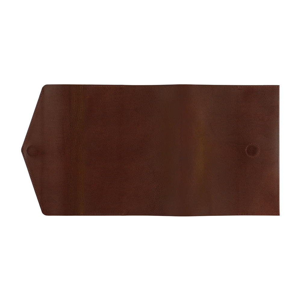 A dark brown leather Hobonichi Techo cover with a pointed triangular flap on the left and a small circular magnet sewn into the right side, shown flat against a solid white background.