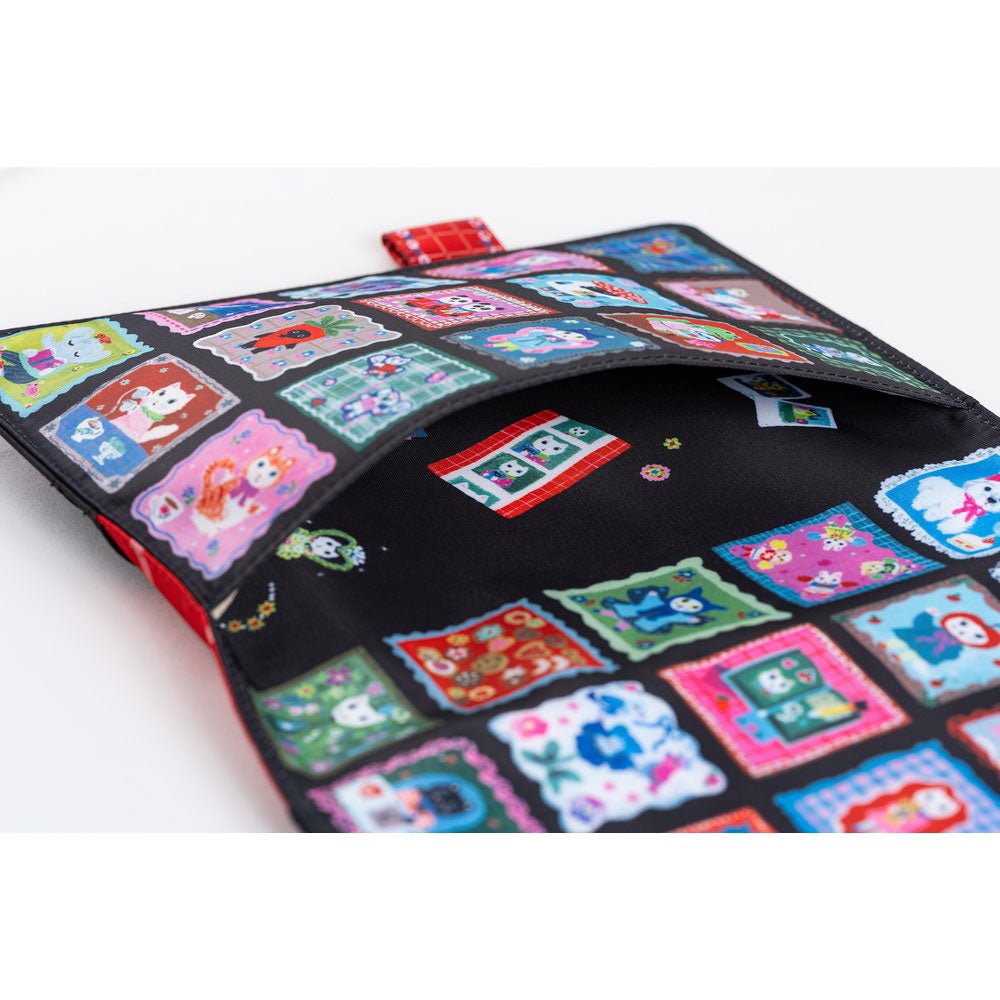 The exterior pocket of a Hobonichi Techo cover decorated with a colorful grid of patchwork-style square panels. Inside the pocket are additional decorative illustrations of whimsical cats and flowers.