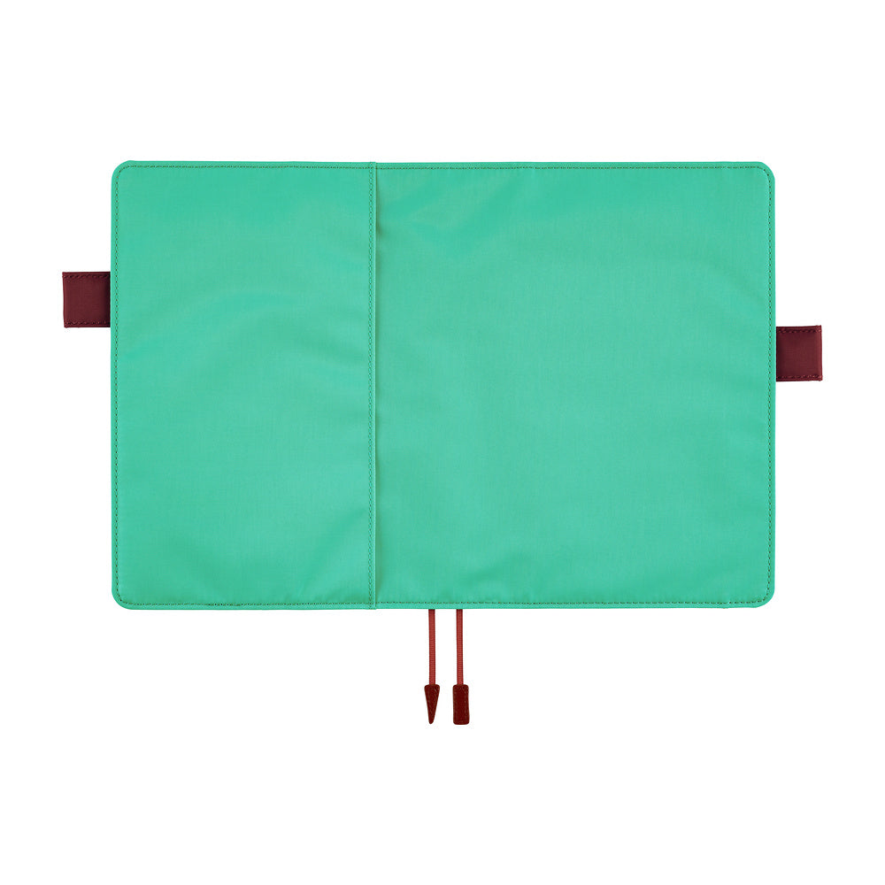 Turquoise Hobonichi Techo cover laid open flat on a white background, showing brown red pen loops and two ribbon bookmarks.