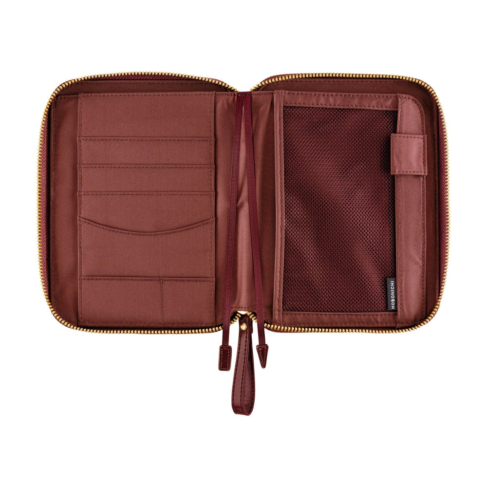 An open burgundy zippered organizer case with gold-tone zippers and multiple interior compartments, shown on a plain white background.