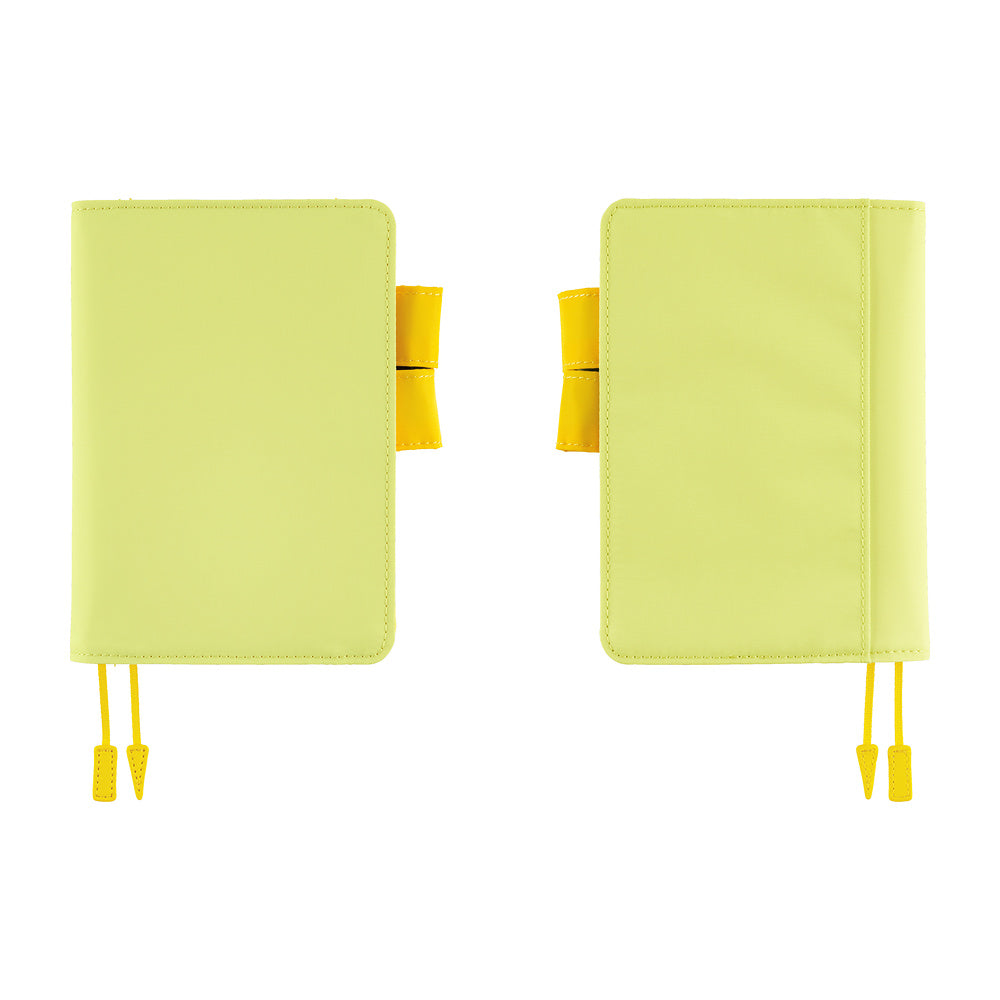 Two light yellow planner covers shown side by side on a plain white background, each with a yellow ribbon bookmark and a small yellow tab detail.