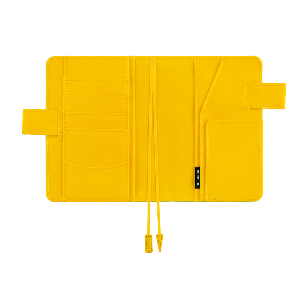 A bright yellow notebook cover with multiple card slots, a pocket, and drawstring closure, shown open on a plain white background.