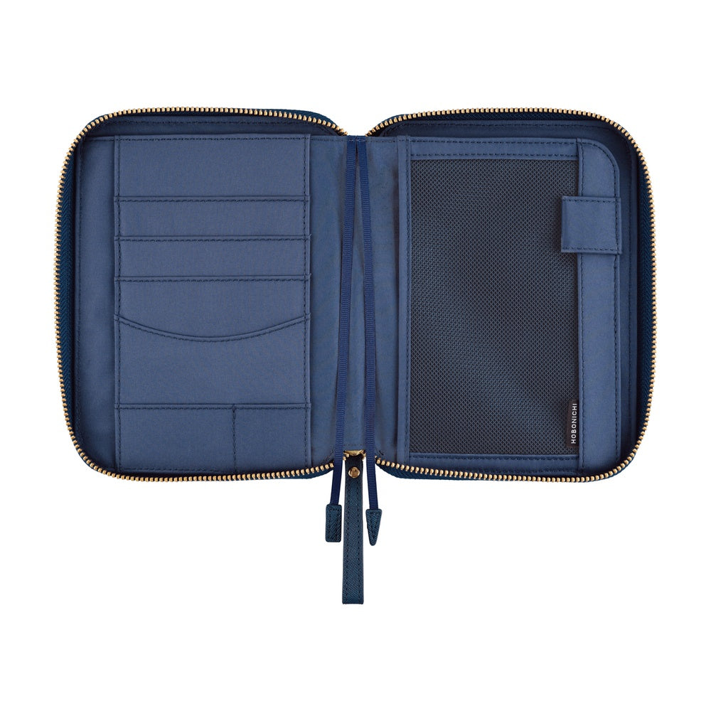 An open navy blue notebook organizer pouch with gold-tone zippers, showing interior card slots, a mesh pocket, and a small side tag on a plain white background.