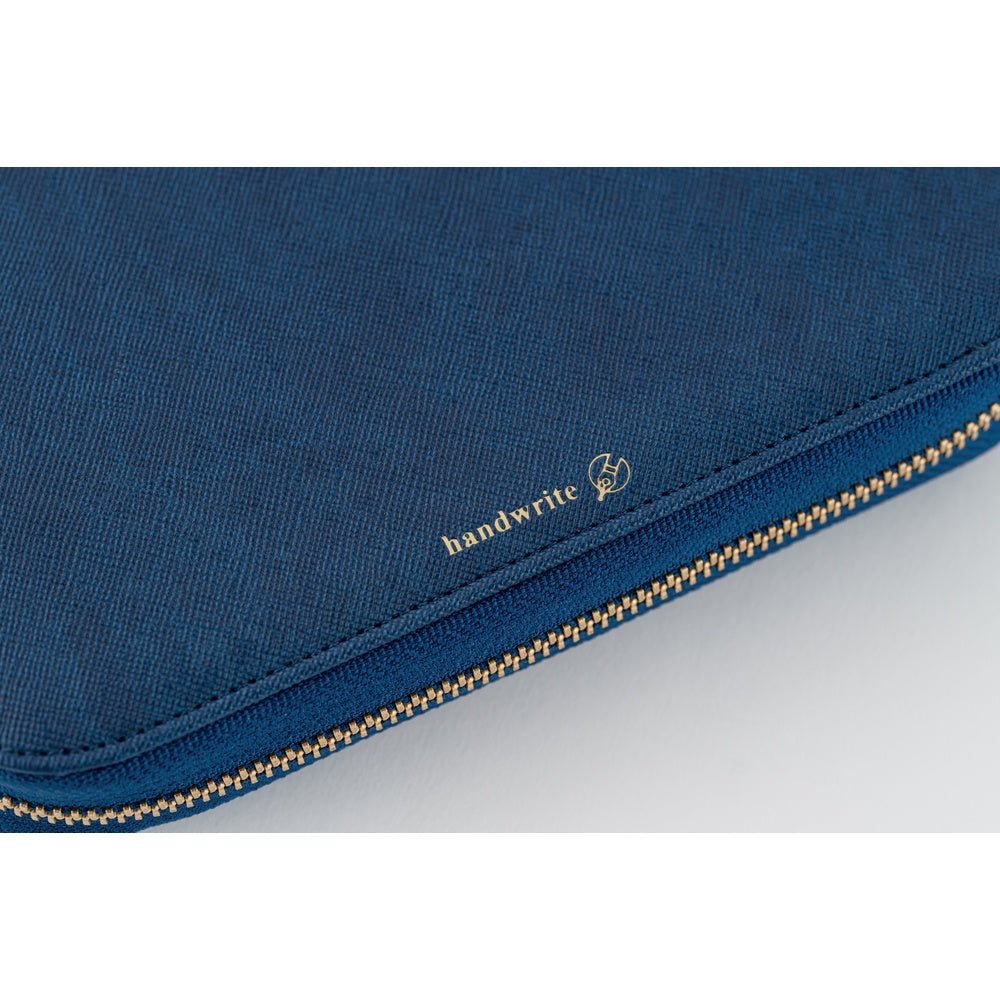 Close-up of a dark blue fabric zippered pouch with a gold zipper and a small gold 'handwrite' logo on the side.