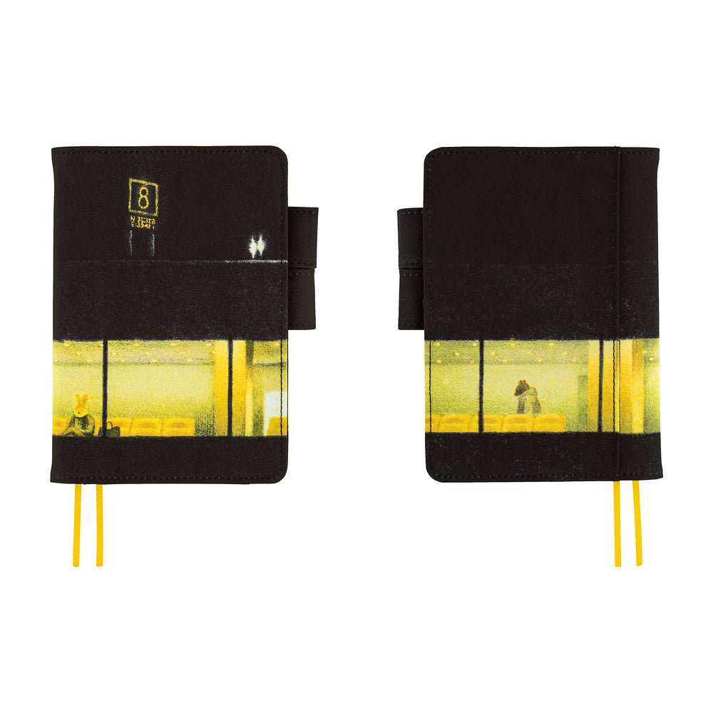 Two black hardcover notebooks with a yellow and black street scene print on the lower half, shown side by side on a white background. Each notebook has a black elastic closure tab and yellow ribbon bookmarks.