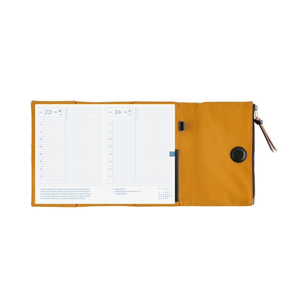 Yellow notebook cover with planner open showing two gridded pages against white background