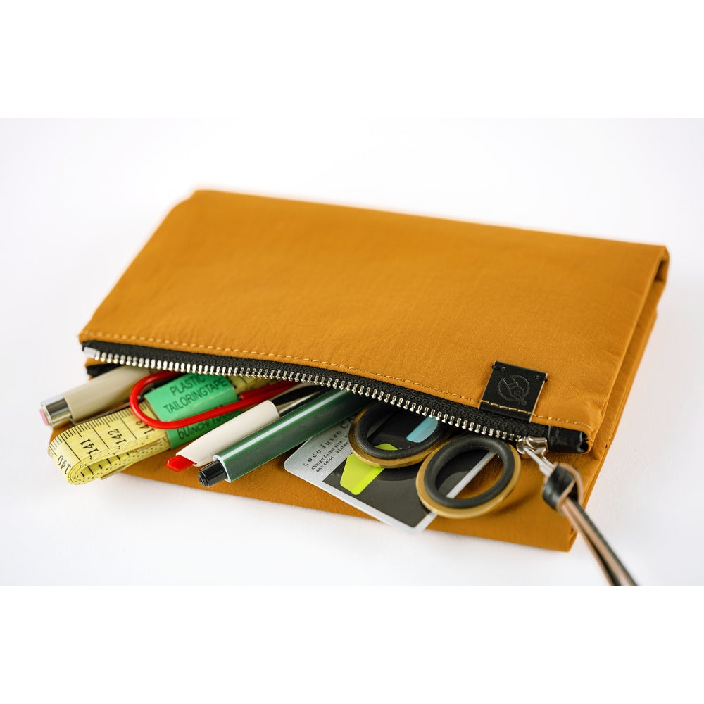 Mustard yellow pouch with stationery items on a white background
