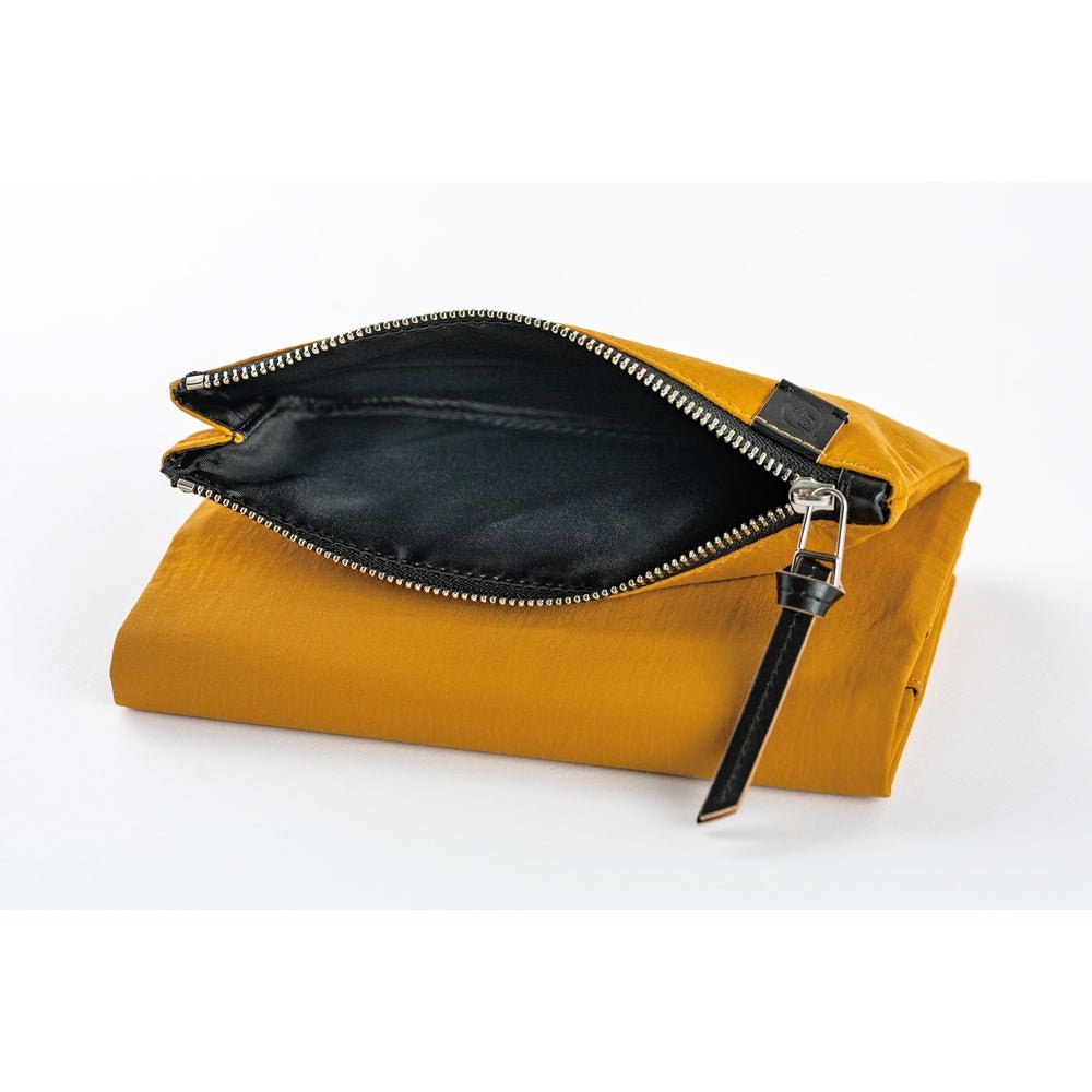 Yellow notebook cover with black interior and zipper on a white background