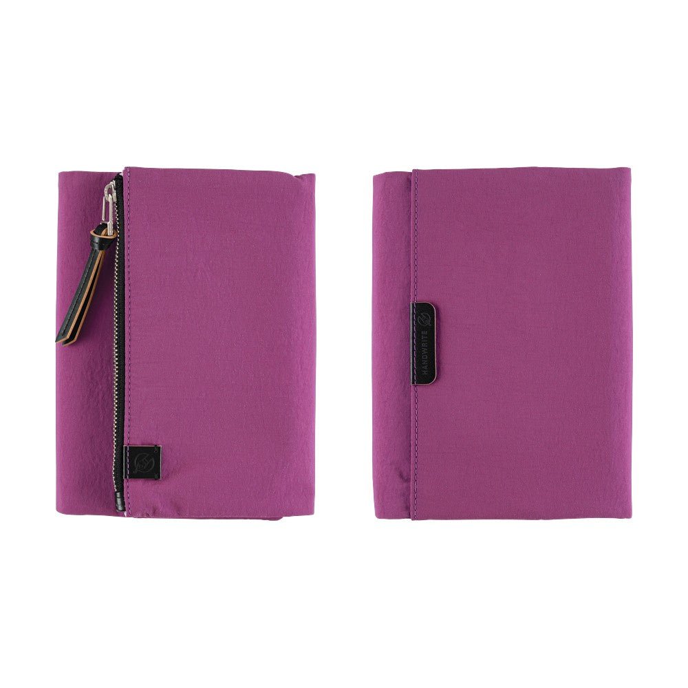 Two views of a purple zippered notebook cover on a white background, showing both the front with a zipper and pull tab, and the back with a pocket.