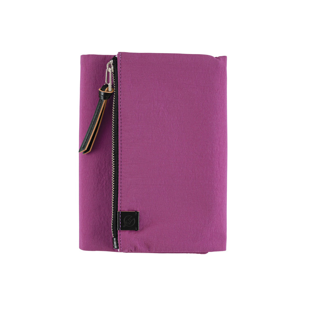 A purple fabric zippered notebook cover with a black zipper, a small black brand patch, and a decorative zipper pull shown on a plain white background.