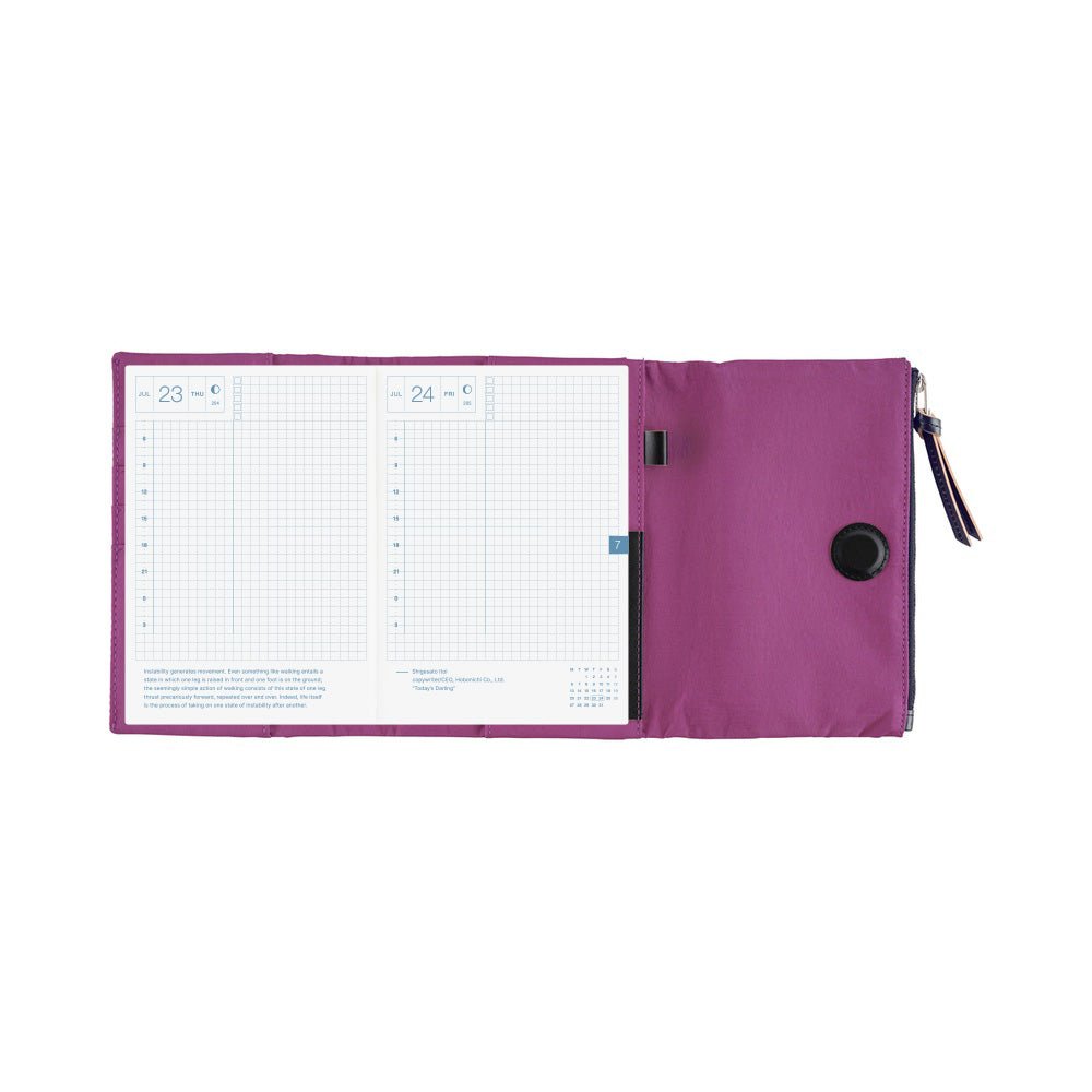 A purple zippered planner cover shown open, displaying two gridded pages and a black magnetic closure on the right.