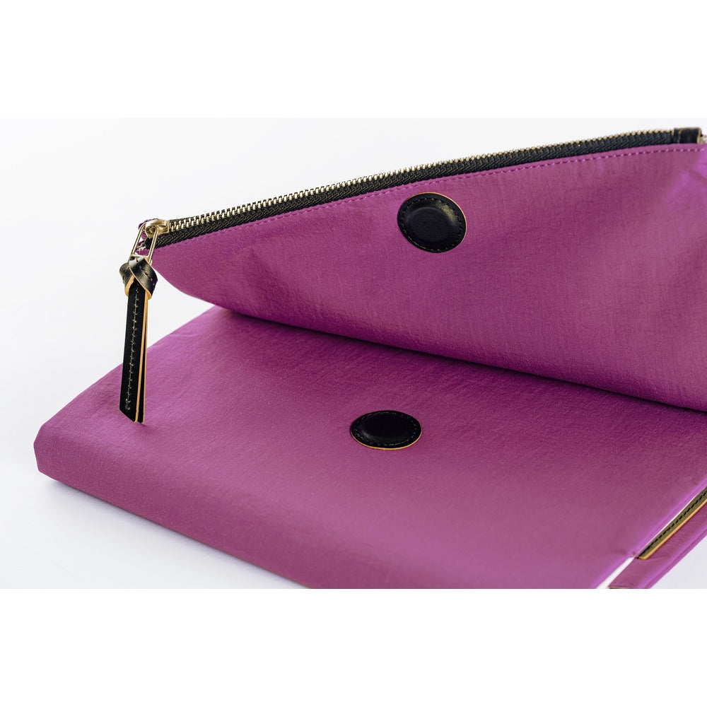 Close-up of the zippered pouch on a purple Hobonichi Tragen cover, showing its black zipper pull on a white background.