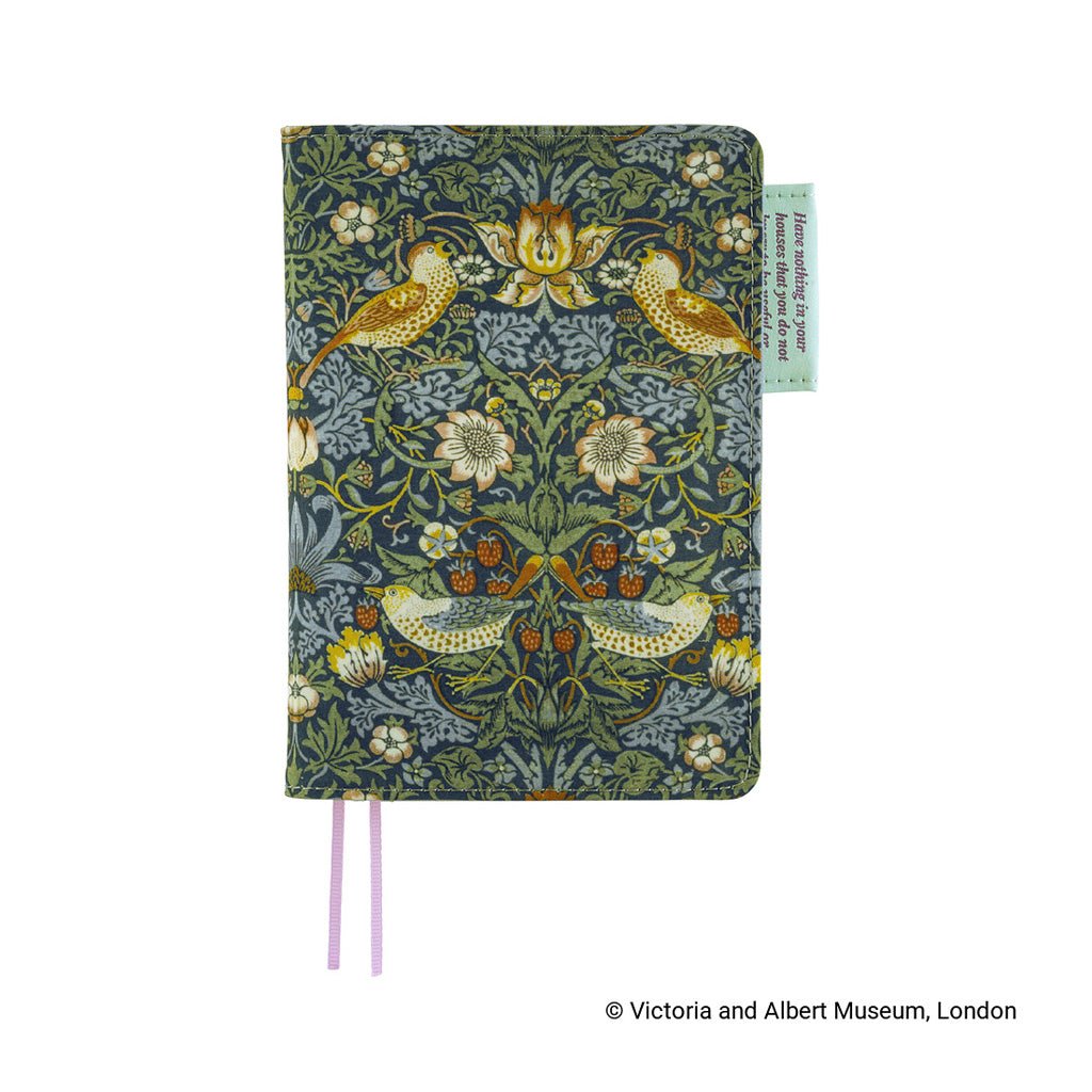 A notebook cover featuring a detailed William Morris-style floral and bird pattern in muted green, blue-gray, and ochre tones, with two lilac ribbon bookmarks and a small light green pen loop on the right side.