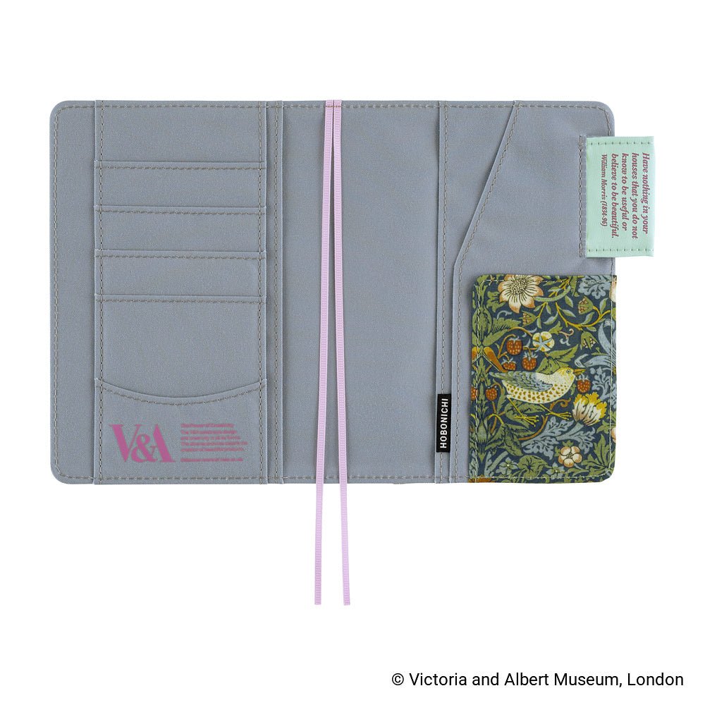A light gray fabric notebook cover open with multiple card slots, two lilac bookmarks, a small floral-patterned pocket, and a mint green pen loop, shown open on a white background.