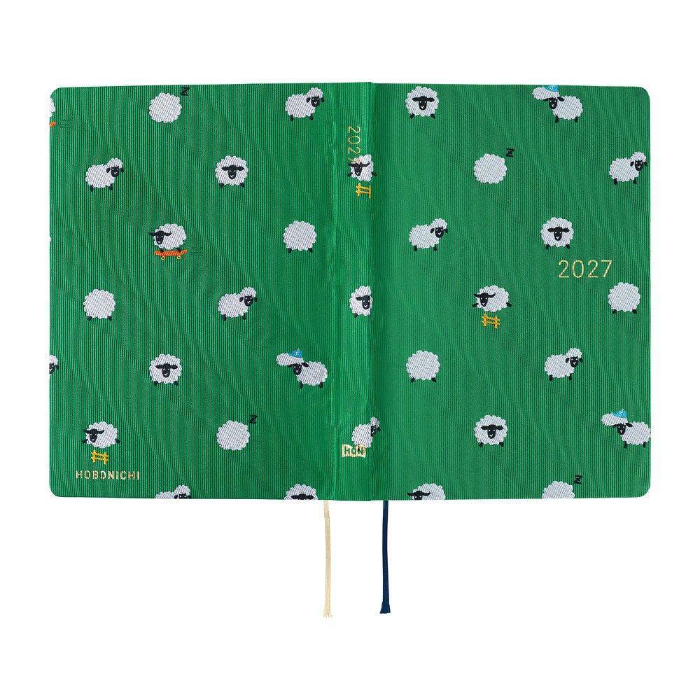 A 2027 Hobonichi HON covered in Bow & Tie fabric woven with a sheep design on a green background