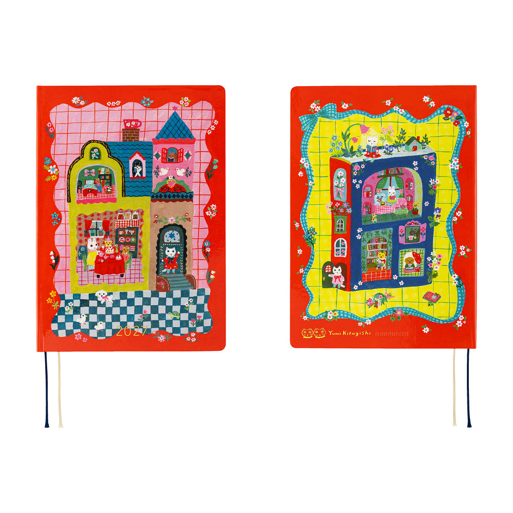 Two hardcover notebooks with whimsical, colorful house illustrations on red covers, shown side by side against a plain white background. One notebook features a pink grid pattern and the other a yellow grid pattern, both with small cartoon characters and floral details.