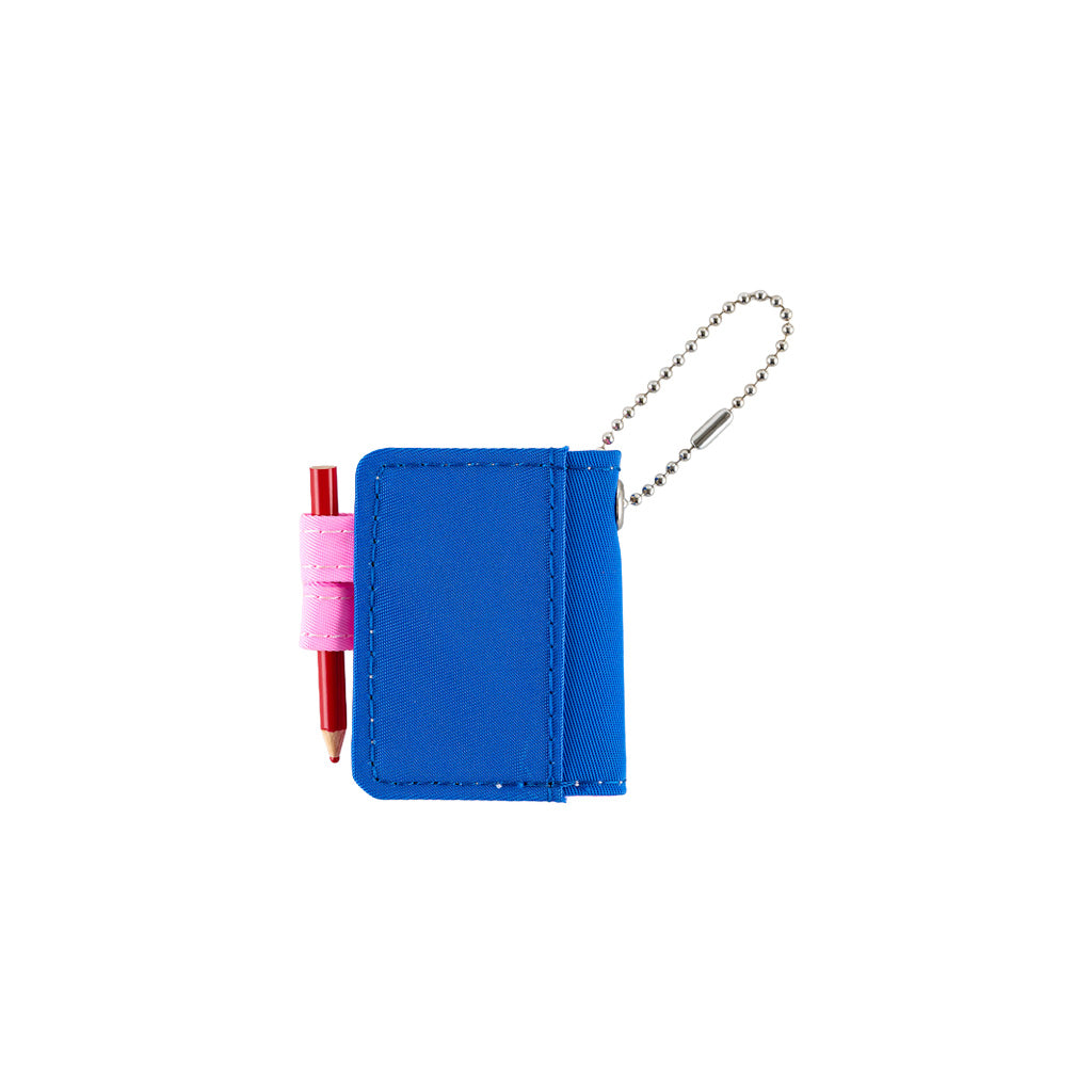 Back of small blue notebook keychain with a silver ball chain and a pink loop holding a red pencil, shown on a plain white background.