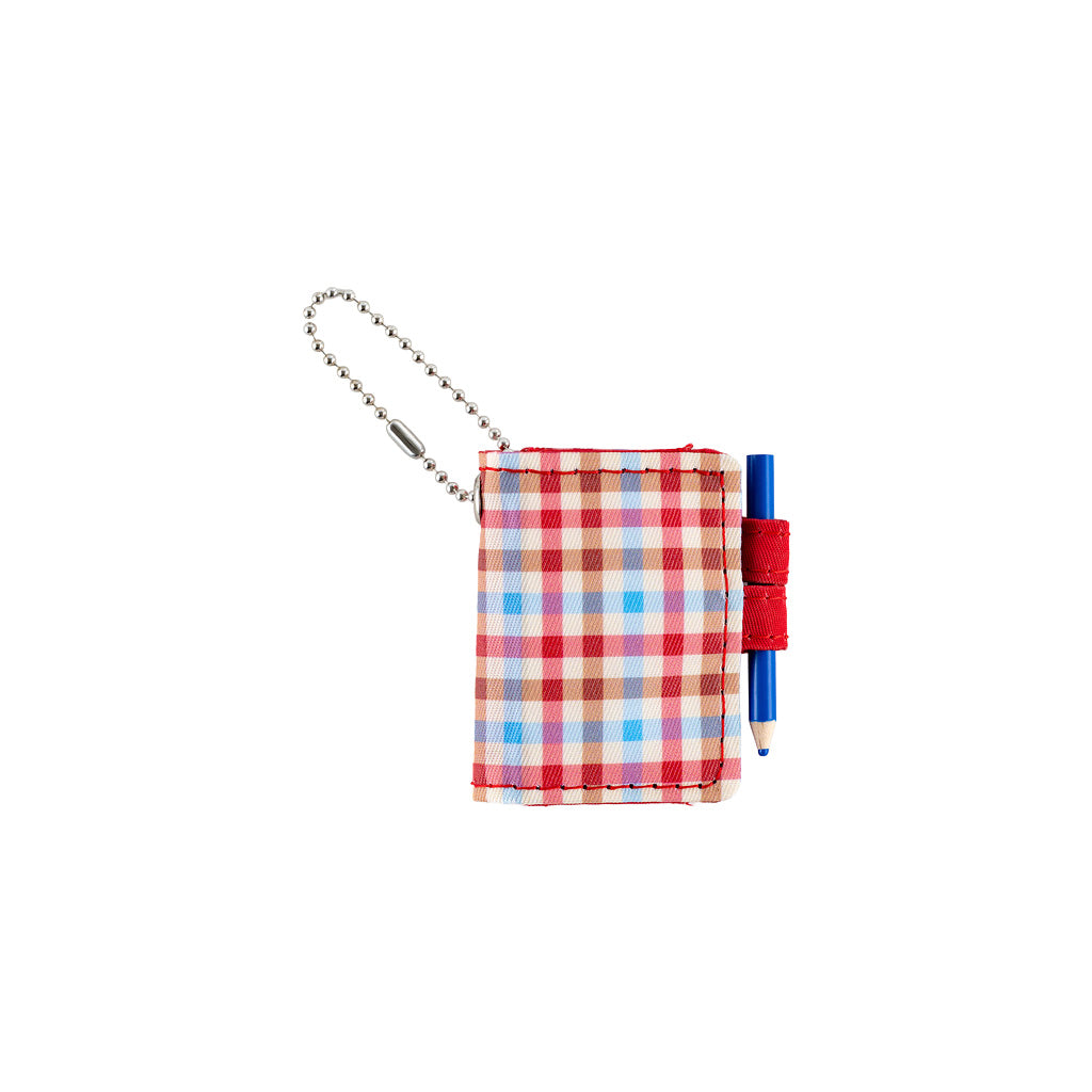 A small plaid notebook keychain with a silver ball chain and a red loop holding a blue pencil, shown on a plain white background.