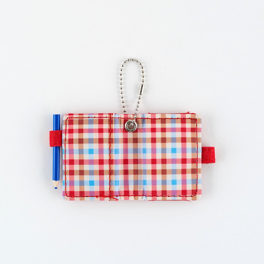 Open small plaid notebook keychain with a silver ball chain and a red loop holding a blue pencil shown on a plain white background.