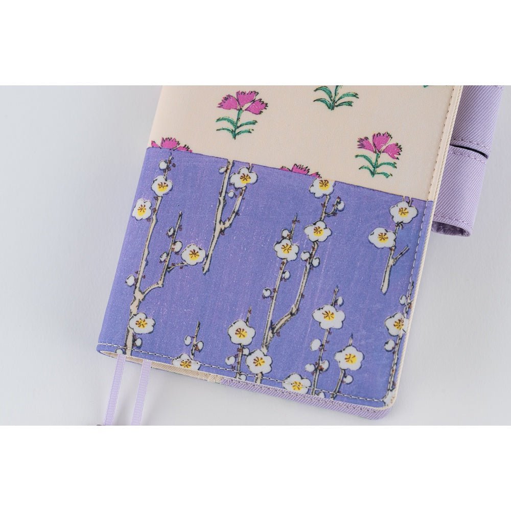 Close up of front of Hobonichi Techo A6 Original Unsodo cover with purple and ivory floral design on white background