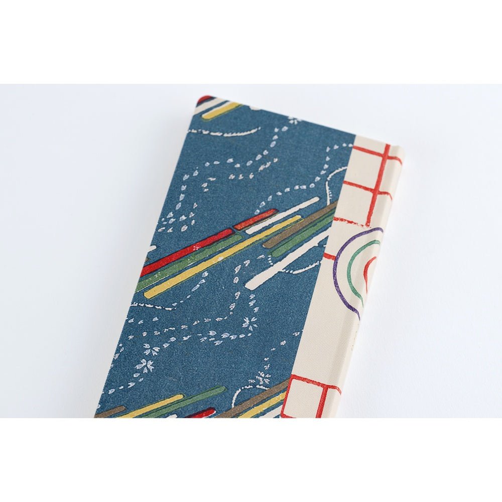 Close up of back of Hobonichi Techo Unsodo spring start 2026 Weeks planner navy background and abstract colorful design on white surface
