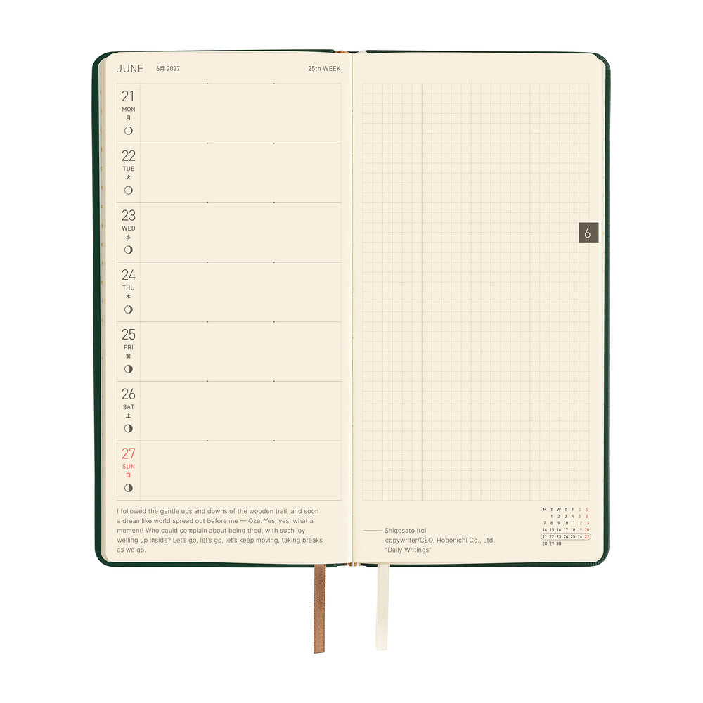 An open weekly planner with cream-colored pages and two ribbon bookmarks.