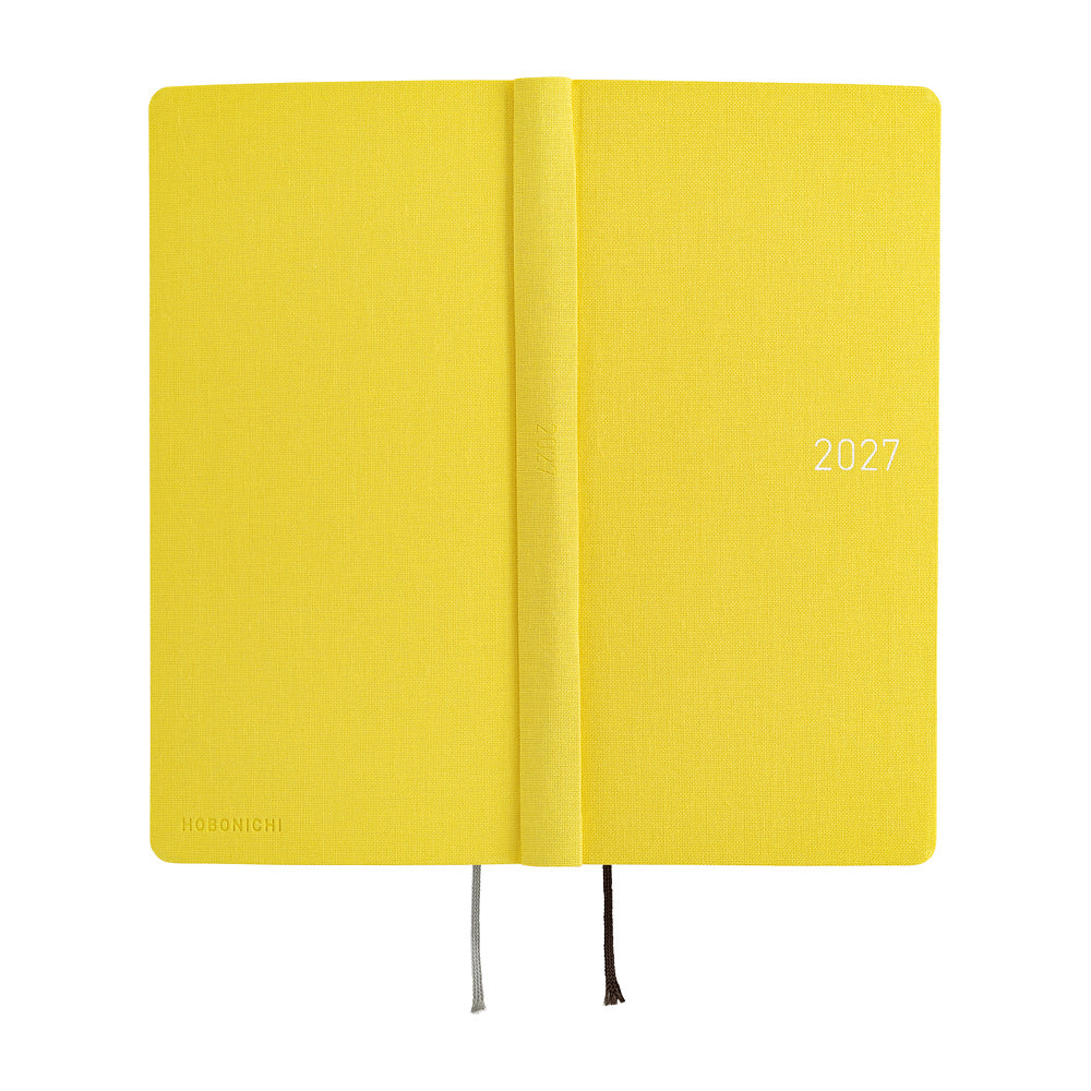 A bright yellow 2027 daily planner opened flat to show front, back and spine.