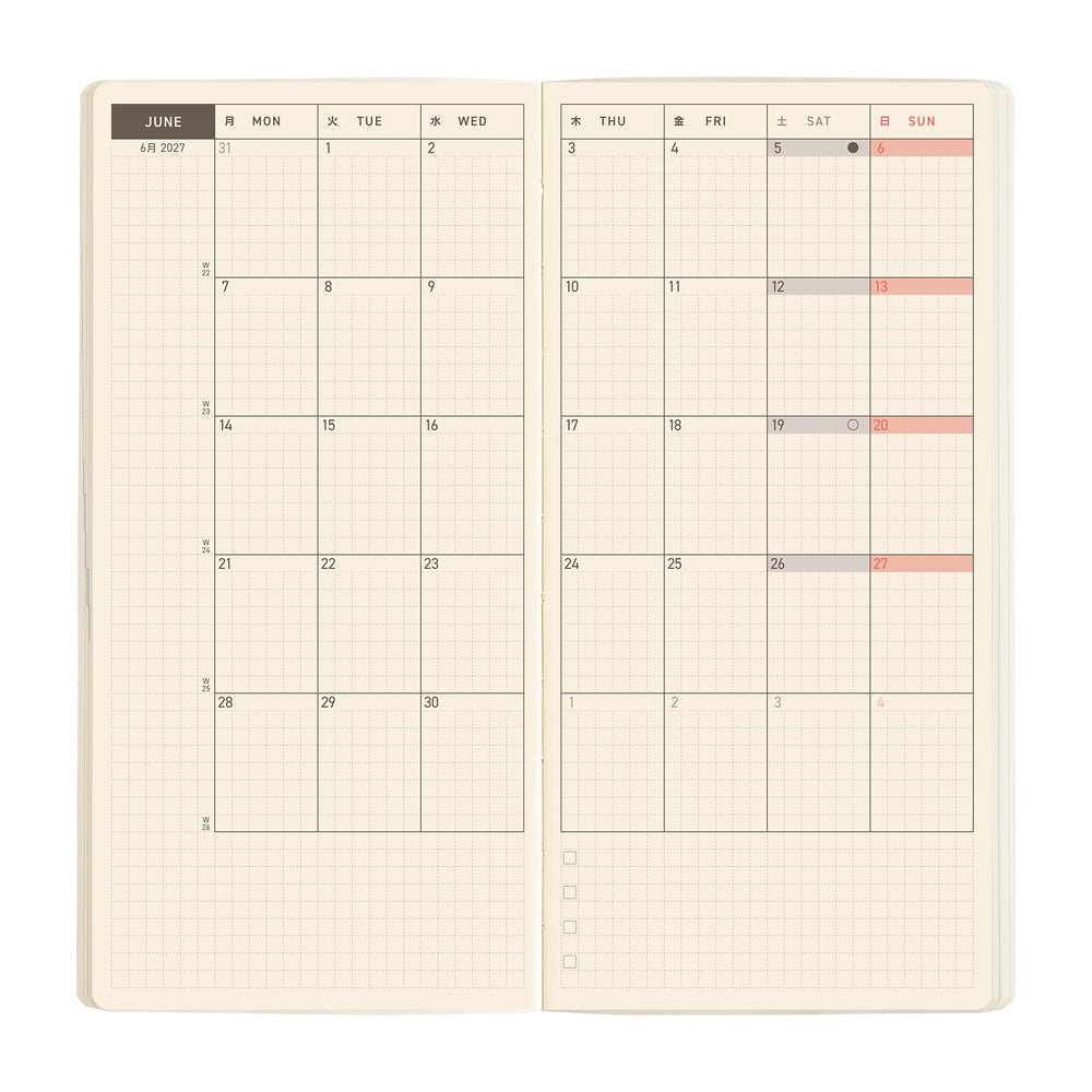 An open planner showing a monthly calendar spread on cream grid paper.