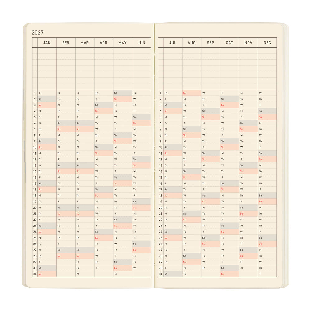 An open planner showing a yearly calendar laid out in a vertical format on cream-colored pages.