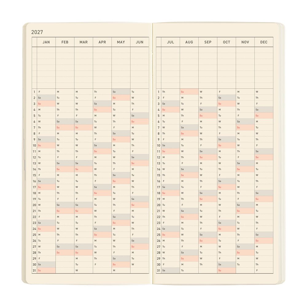 An open planner showing a yearly calendar laid out in a vertical format on cream-colored pages.