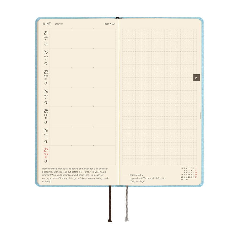 An open planner showing a weekly layout page on the left with dates and a short quote, and a grid page on the right.
