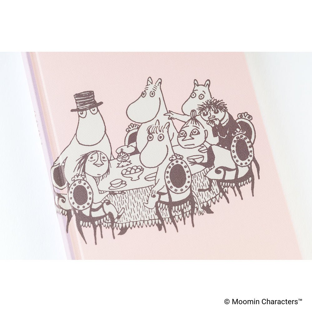A close-up of a planner cover featuring illustrations showing Moomin characters gathered around a table.