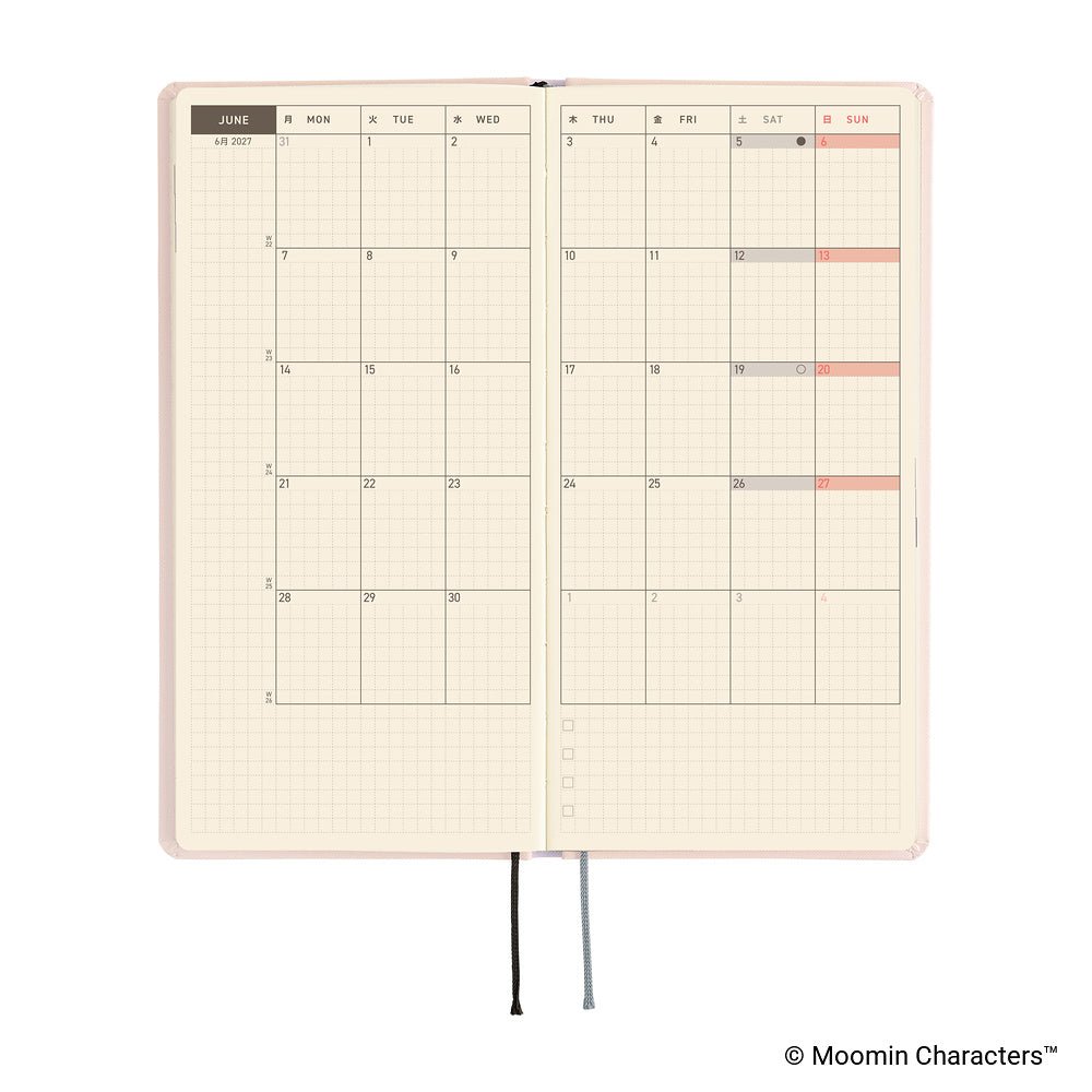 An open planner with a monthly calendar spread on cream grid pages, shown on a white background.