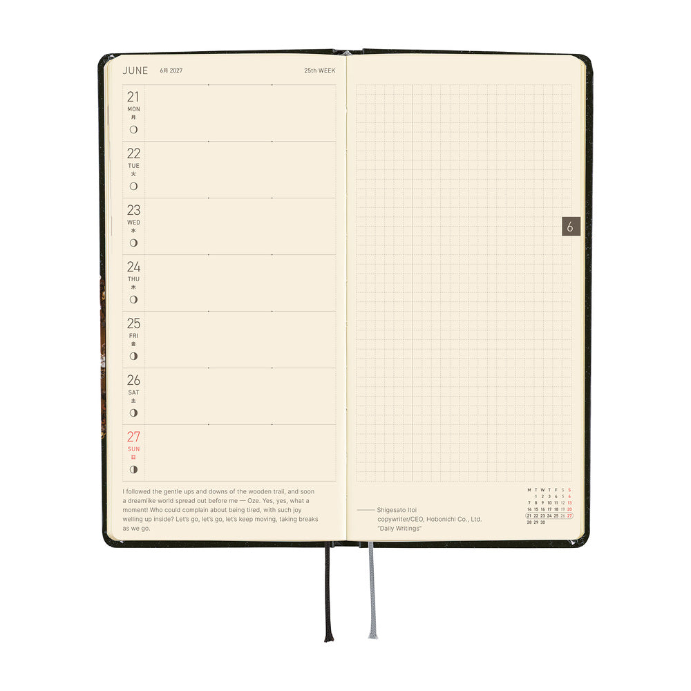 An open planner showing a weekly spread with a left column for Monday through Sunday and a blank grid page on the right.