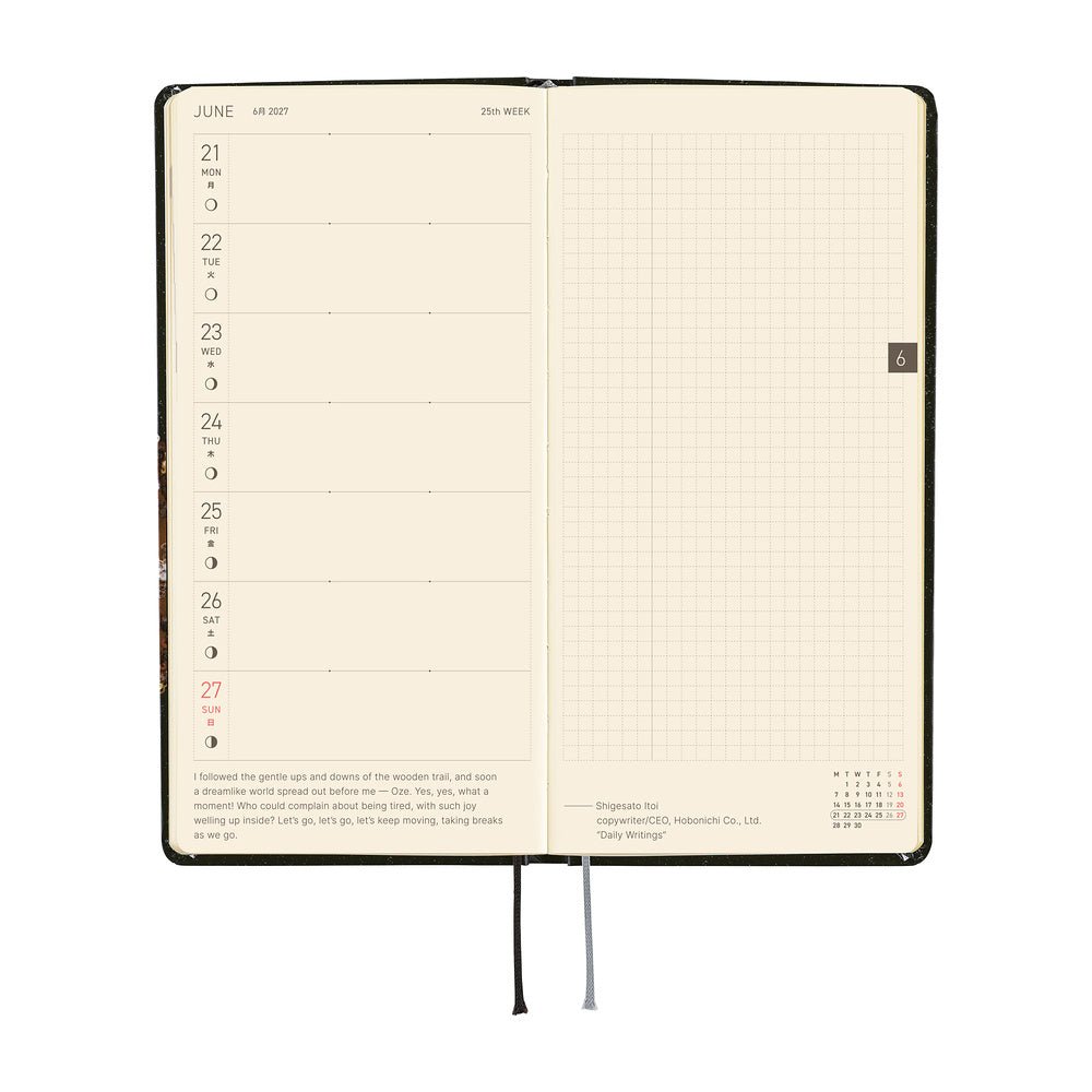 An open planner showing a weekly spread with a left column for Monday through Sunday and a blank grid page on the right.