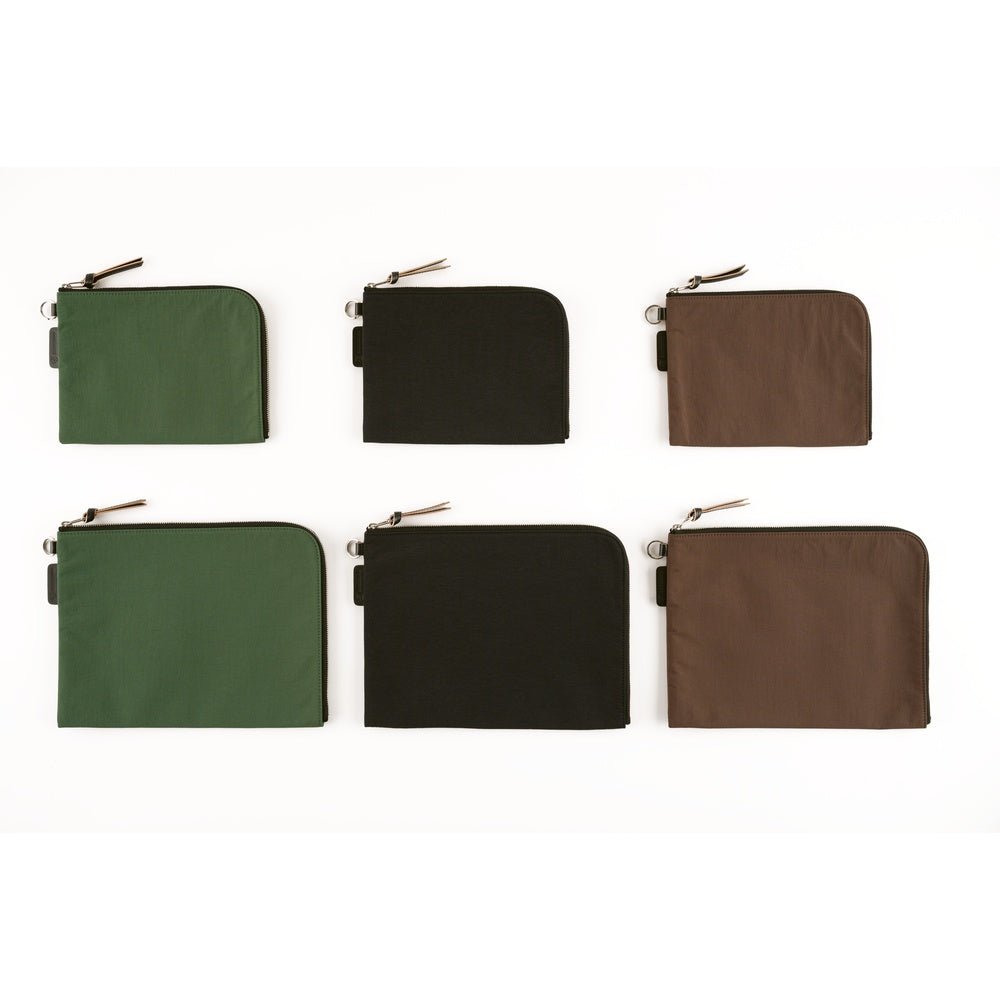 Six zippered pouches arranged in two rows of three on a white background, shown in green, black, and brown. Each pouch has a rounded bottom corner and a small metal zipper pull.